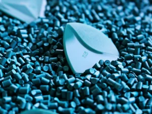 Artistic shot of guitar picks on a textured surface of blue plastic granules.