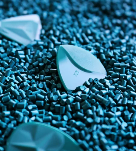 Artistic shot of guitar picks on a textured surface of blue plastic granules.